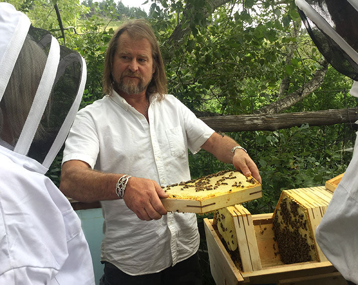 Corwin Bell holding a Cathedral Hive comb which has superior support with full attachment to the 3 sided bar